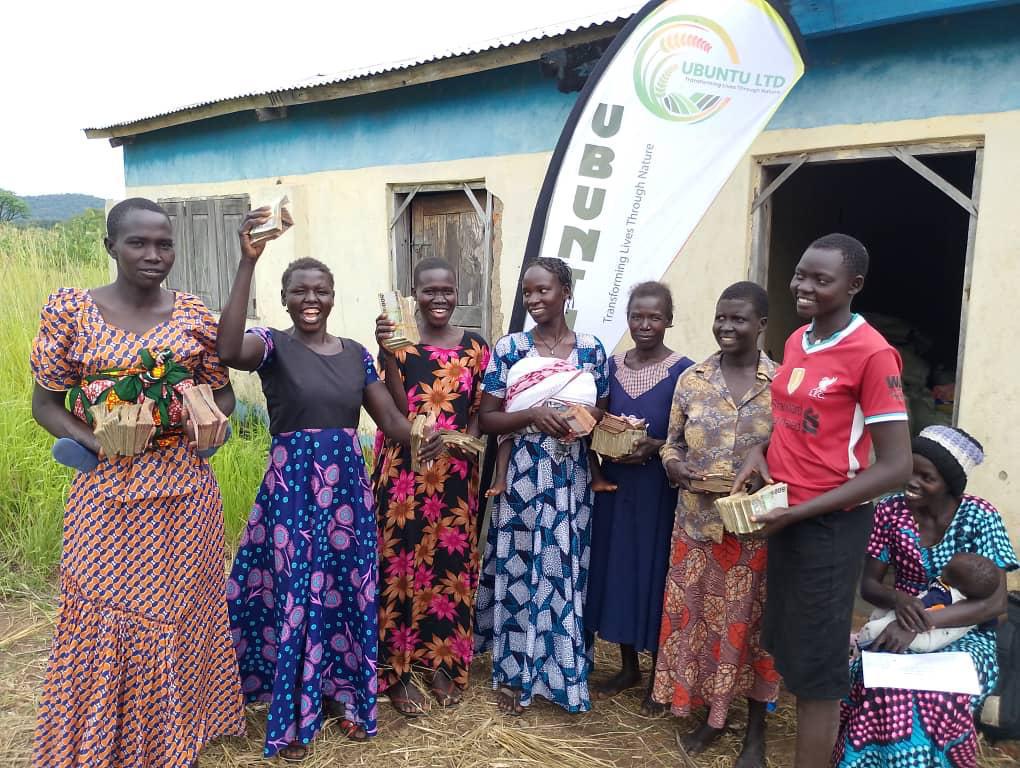 Smiling women shea collectors holding their earnings outside the Ubuntu Ltd collection centre